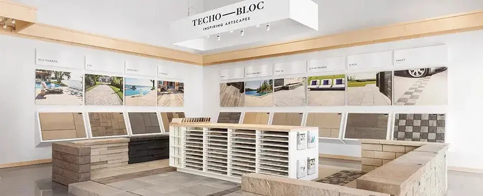 Interior of a Techo-Bloc showroom featuring wall-mounted paver samples and stacked product
displays—supporting local rep inquiries.
