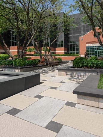 Techo-Bloc&#x27;s commercial Ocean Grande patio slab and Valet paver installed in a basketweave pattern for an office outdoor landscape.