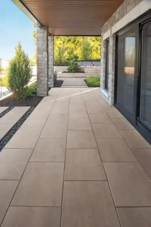 A patio with Para concrete slabs by Techo-Bloc in a Caffè Crema color and a smooth texture