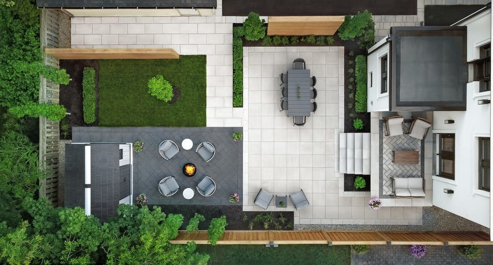 Aerial view of a backyard complete with a dining area, firepit and walkway.