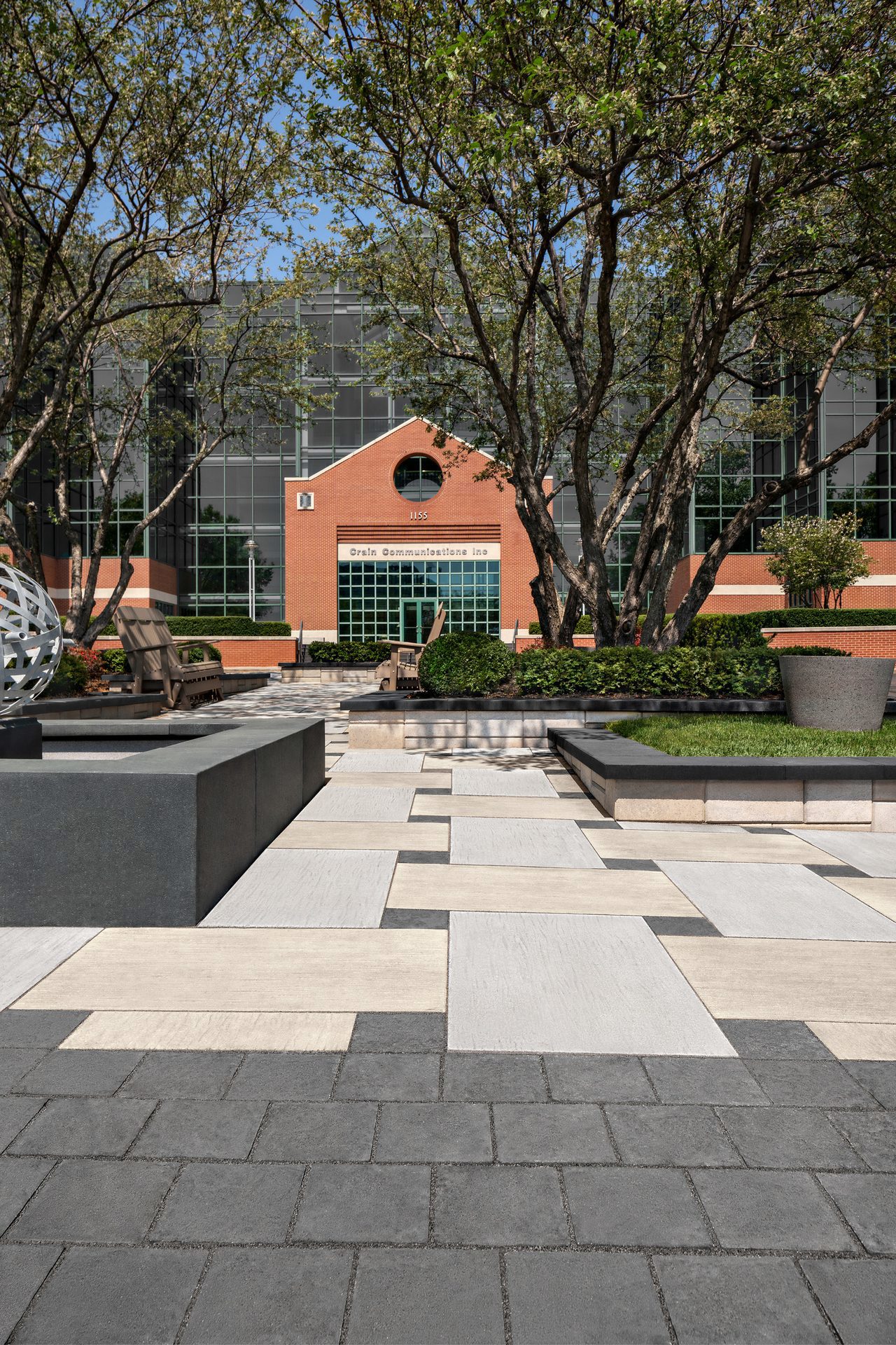 View of office courtyard facing building entrance using Techo-Bloc&#x27;s Ocean Grande Slab and Valet Paver.